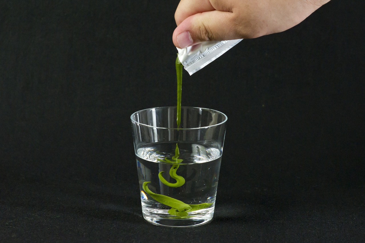 Pressed matcha dissolving in a glass